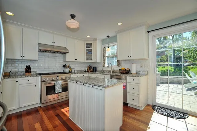 a kitchen with cabinets appliances and a large window