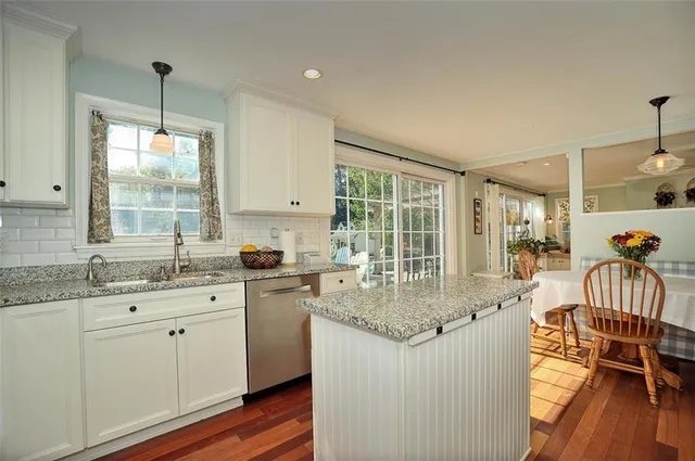 a kitchen with center island wooden floor and a view of dining table
