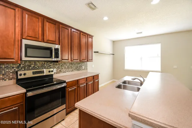 a kitchen with a stove a sink and a microwave