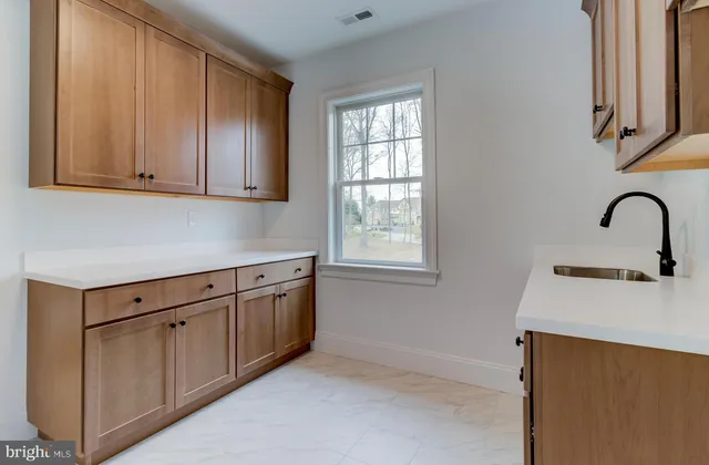 a kitchen with granite countertop white cabinets and sink