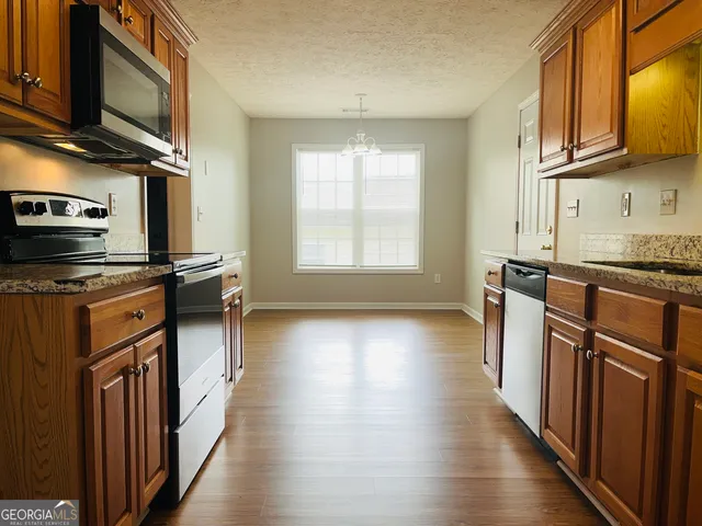 a kitchen with stainless steel appliances granite countertop a stove a sink and a microwave