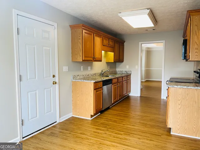 a kitchen with stainless steel appliances granite countertop a stove a sink and a refrigerator
