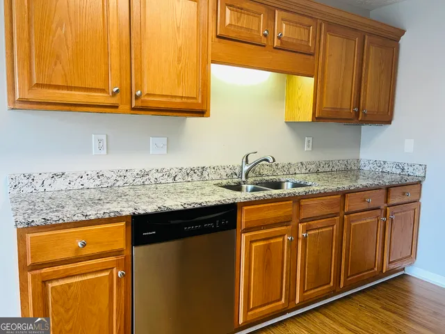 a kitchen with stainless steel appliances granite countertop wooden cabinets a sink and dishwasher