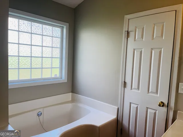 a bathroom with a bathtub and window