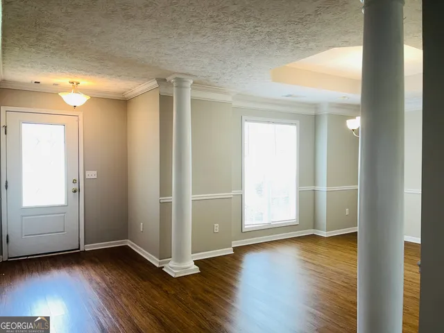 an empty room with wooden floor & closet area