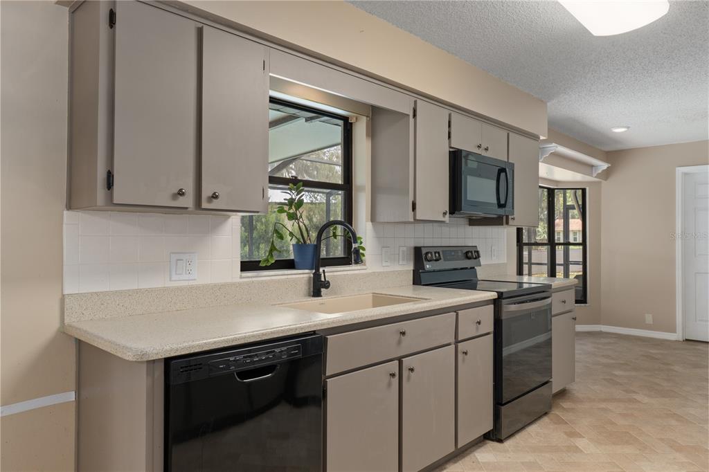 2481 South Summerwood Point Inverness, FL 34450 - Photo 13 of 38 a kitchen with a sink dishwasher stove and microwave