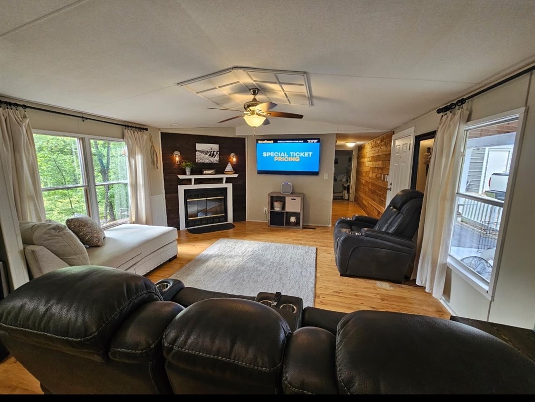 390 Wharf Road Savannah, TN 38372 - Photo 6 of 17 Living area featuring wood-finish flooring, a ceiling fan with integrated lighting, and multiple windows