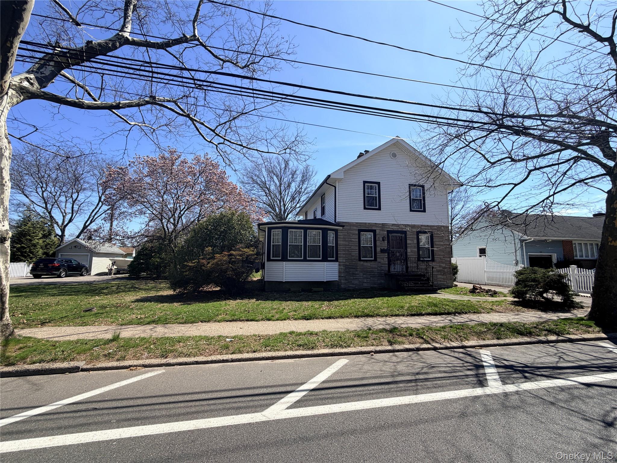 245 Woodbury Road Hicksville, NY 11801 - Photo 4 of 37 a view of a house with a big yard and large trees