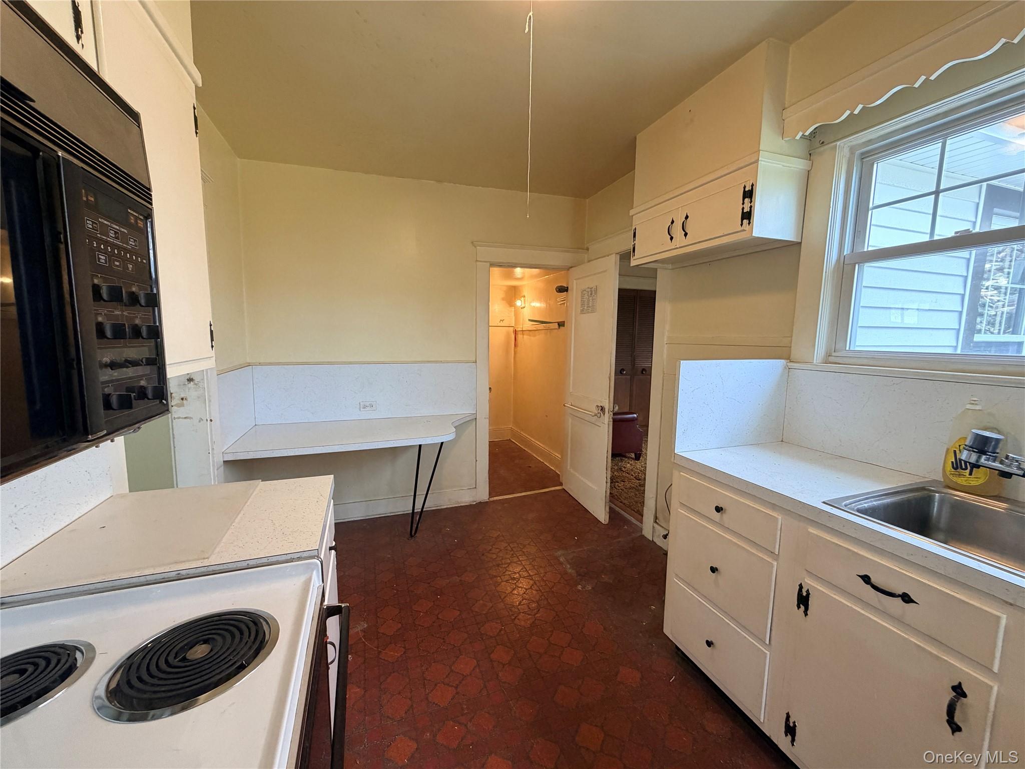 245 Woodbury Road Hicksville, NY 11801 - Photo 10 of 37 a kitchen with a refrigerator and white cabinets