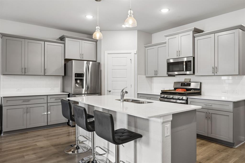 638 Hazeltine Road Red Oak, TX 75154 - Photo 11 of 29 a kitchen with kitchen island white cabinets and stainless steel appliances