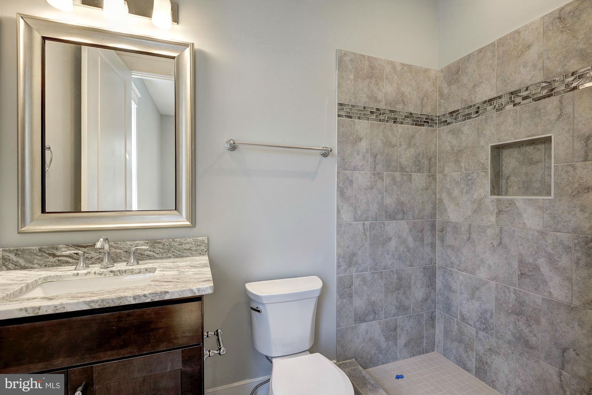 2108 Windsor Road Alexandria, VA 22307 - Photo 18 of 30 a bathroom with a granite countertop sink toilet and shower