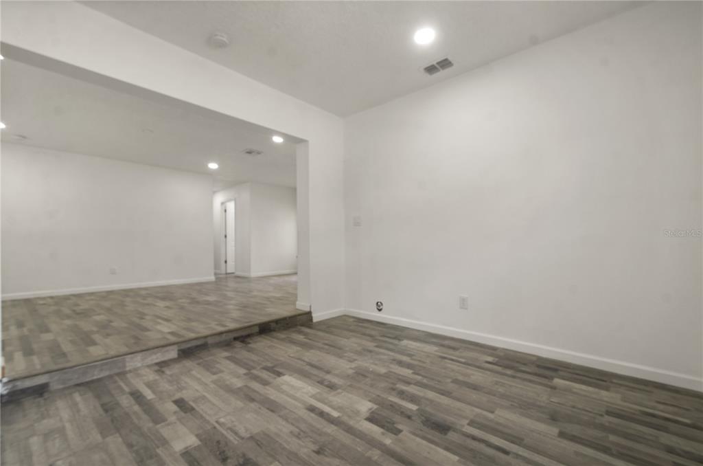 4385 Cassius Street Orlando, FL 32811 - Photo 13 of 21 an empty room with wooden floor and windows