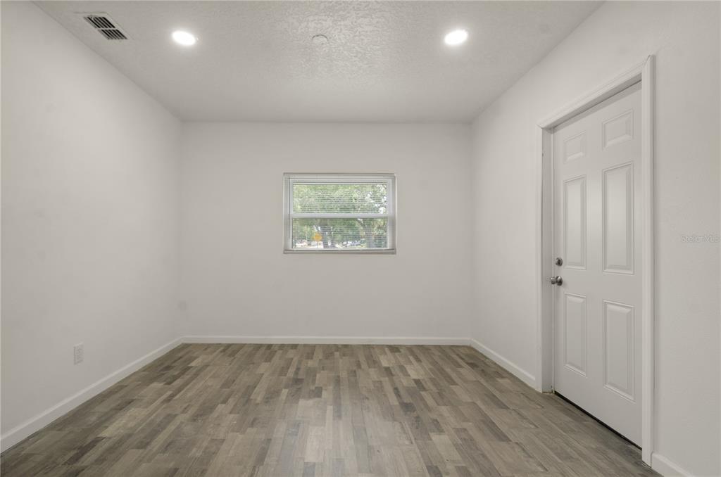 4385 Cassius Street Orlando, FL 32811 - Photo 14 of 21 an empty room with wooden floor and window
