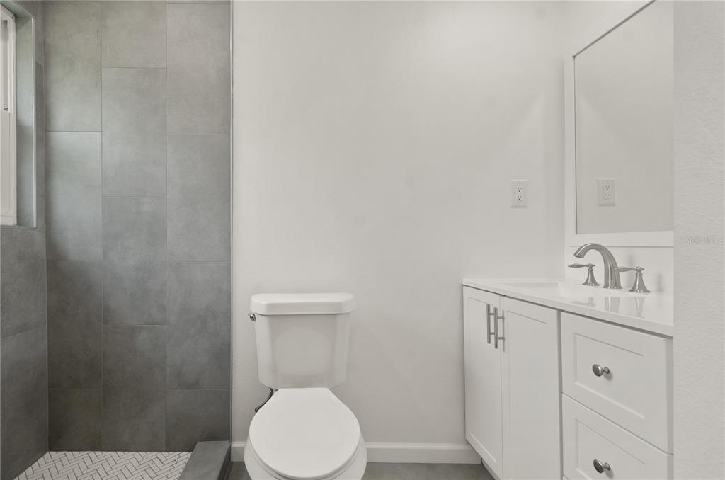 4385 Cassius Street Orlando, FL 32811 - Photo 17 of 21 a bathroom with a toilet a sink a vanity and mirror