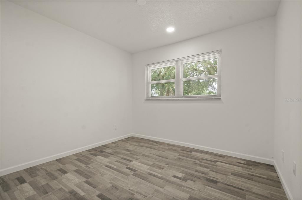 4385 Cassius Street Orlando, FL 32811 - Photo 20 of 21 an empty room with wooden floor and windows
