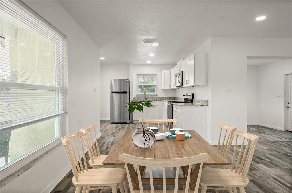 4385 Cassius Street Orlando, FL 32811 - Photo 3 of 21 a view of a dining room with furniture a kitchen and chandelier