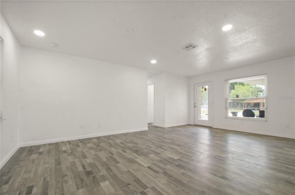 4385 Cassius Street Orlando, FL 32811 - Photo 8 of 21 an empty room with wooden floor and windows