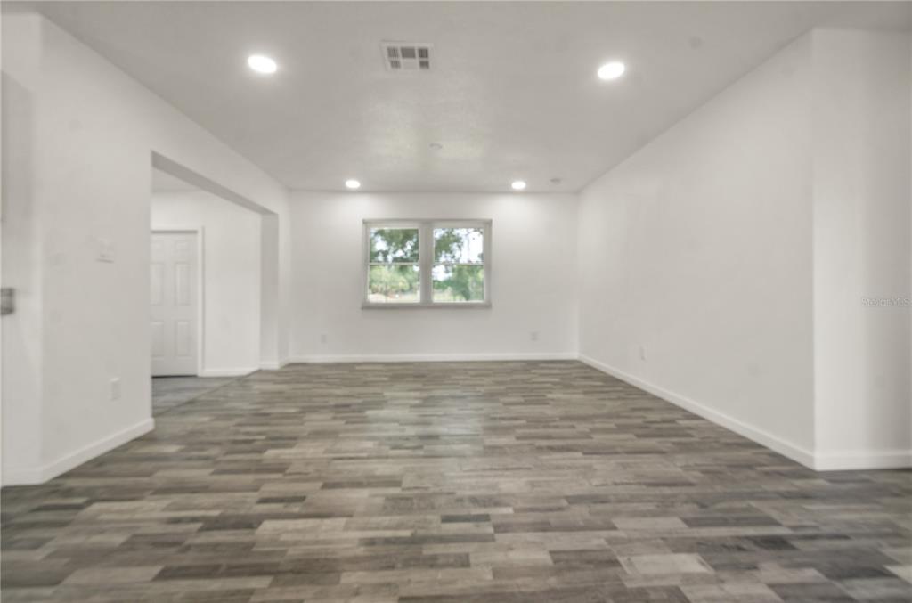 4385 Cassius Street Orlando, FL 32811 - Photo 9 of 21 an empty room with wooden floor and windows