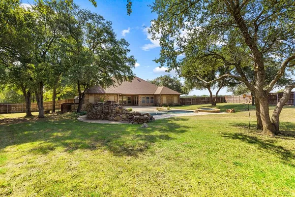 a view of yard with swimming pool and trees