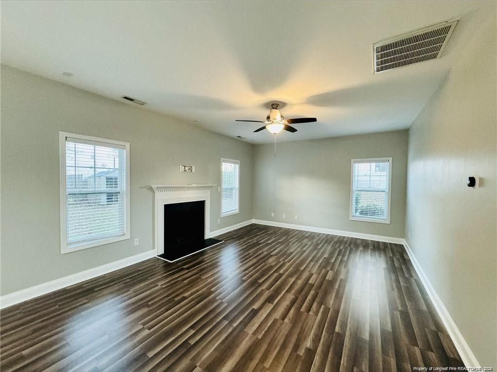 84 Old Glory Lane Cameron, NC 28326 - Photo 4 of 8 an empty room with wooden floor fireplace and windows
