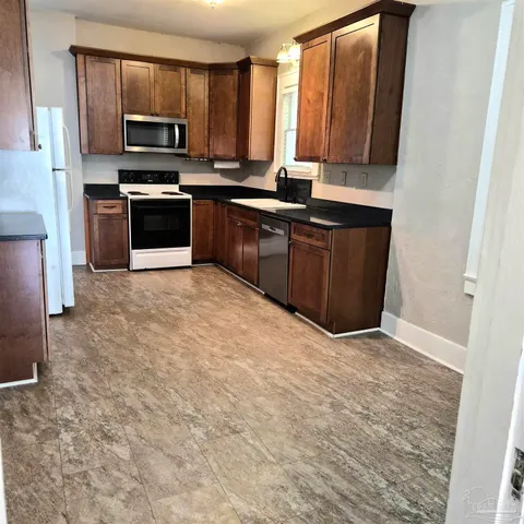 a kitchen with stainless steel appliances granite countertop a stove a sink and a microwave