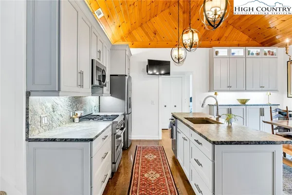 a kitchen with stainless steel appliances granite countertop a sink stove and refrigerator