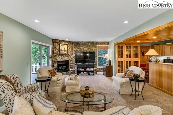 a living room with fireplace furniture and a large window