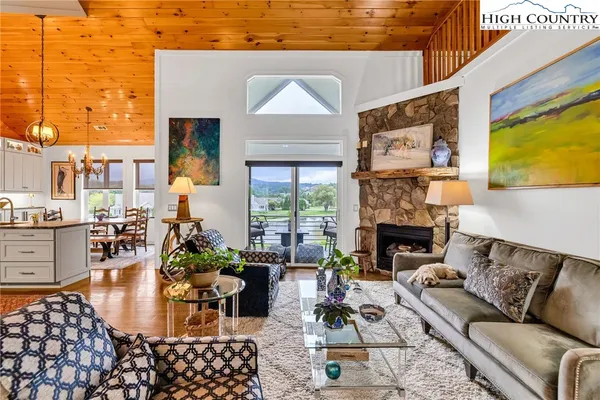 a living room with furniture large window and fireplace
