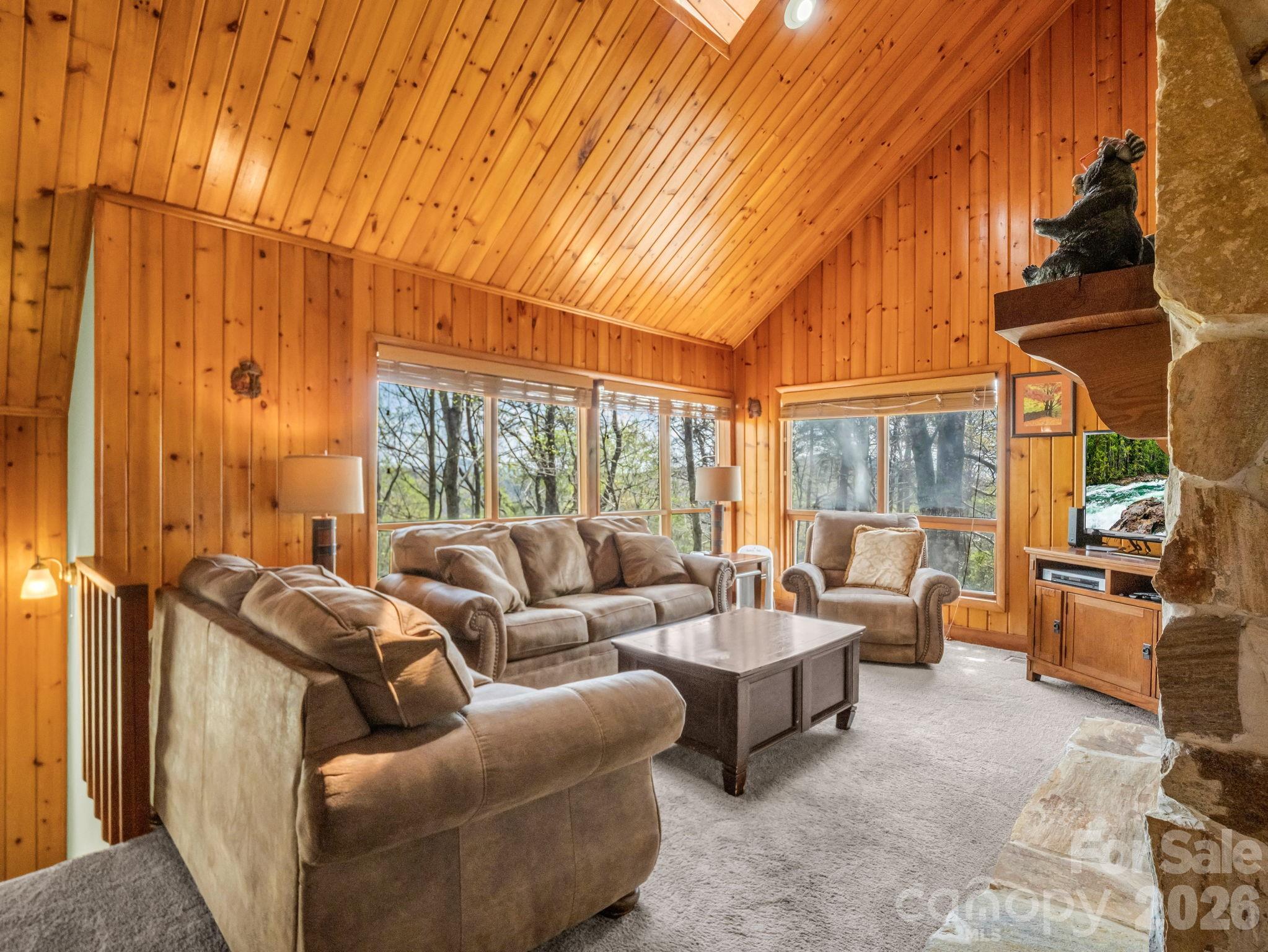 307 Watership Road Lake Lure, NC 28746 - Photo 8 of 48 a living room with furniture a fireplace and large windows