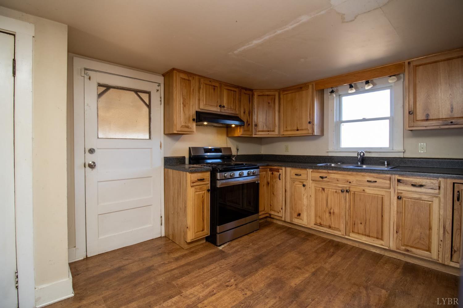 3039 T N Snow Road Nathalie, VA 24577 - Photo 11 of 50 a kitchen with stainless steel appliances granite countertop a stove a sink and a microwave