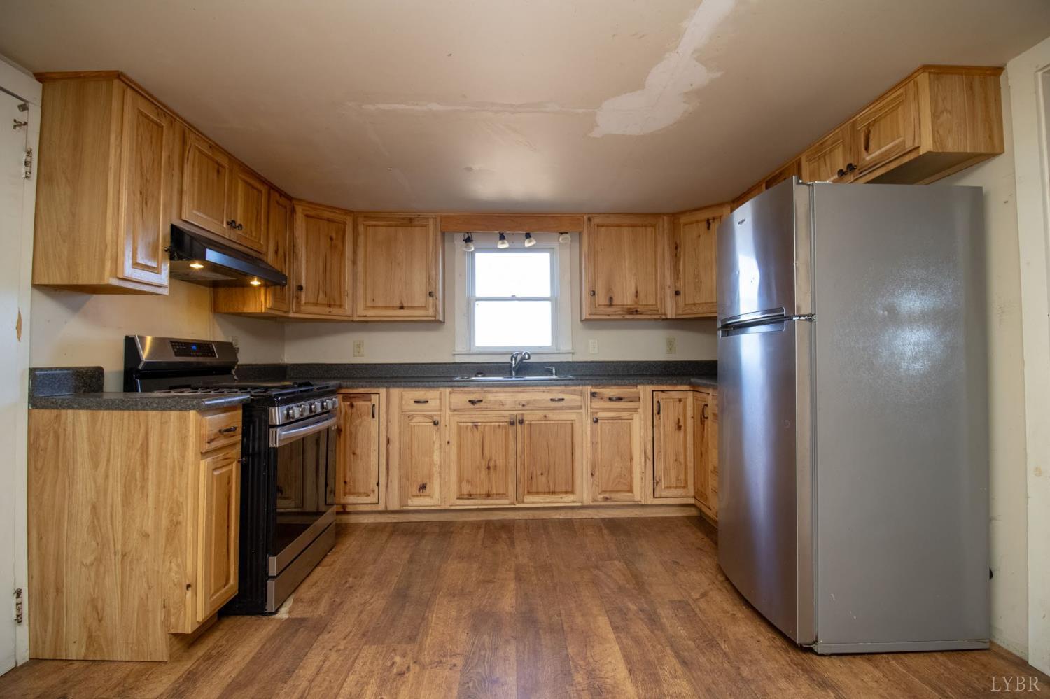 3039 T N Snow Road Nathalie, VA 24577 - Photo 12 of 50 a kitchen with granite countertop wooden floors and stainless steel appliances