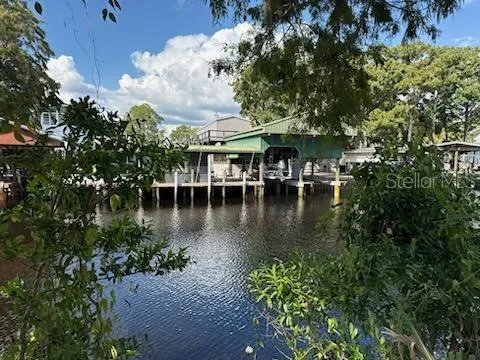 a view of a lake with a table and chairs under an umbrella