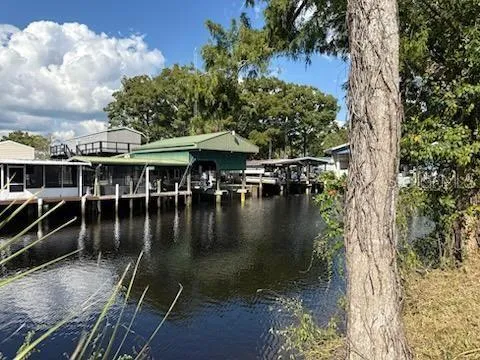 a view of a lake with a table and chairs under an umbrella