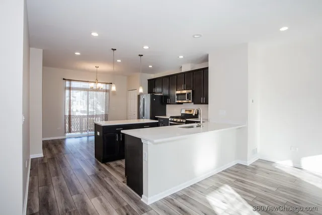 a kitchen with a sink a kitchen island and stainless steel appliances