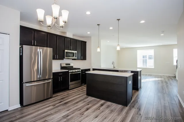 a view of kitchen with granite countertop cabinets and refrigerator