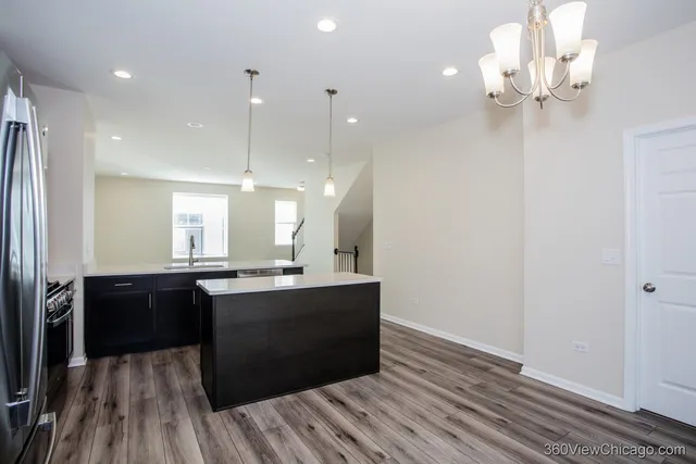 a kitchen with kitchen island a sink stove and refrigerator
