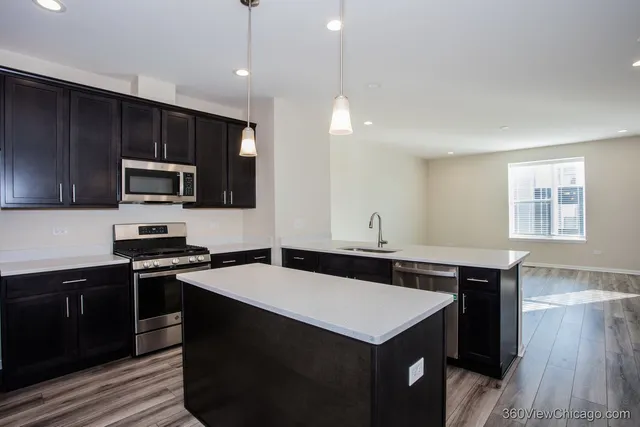 a kitchen with a sink a counter top space stainless steel appliances and cabinets