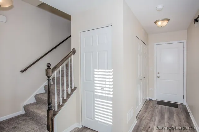 a view of hallway with stairs and wooden floor