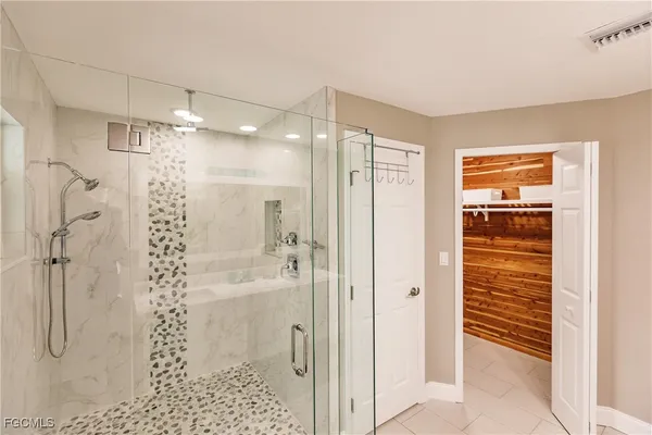 a spacious bathroom with a double vanity sink a mirror and a shower