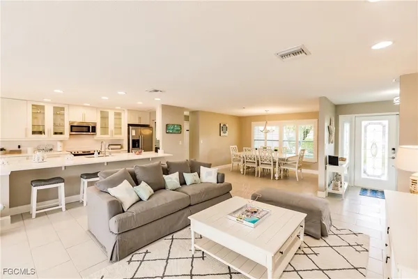 a living room with furniture a flat screen tv and a large window