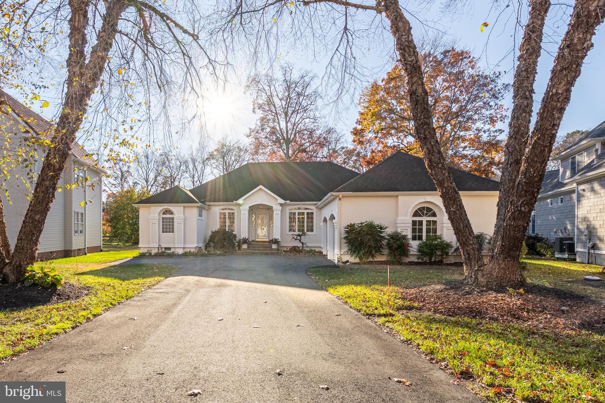 a front view of a house with a yard outdoor seating and covered with trees
