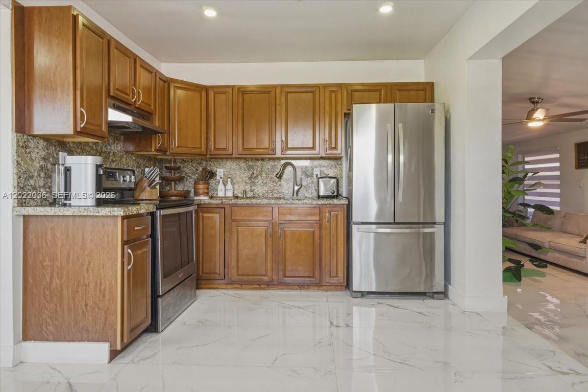 120 West 50th Street Hialeah, FL 33012 - Photo 2 of 22 a kitchen with stainless steel appliances granite countertop a refrigerator a stove a sink and a cabinets