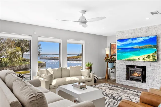 a living room with furniture a large window and a fireplace