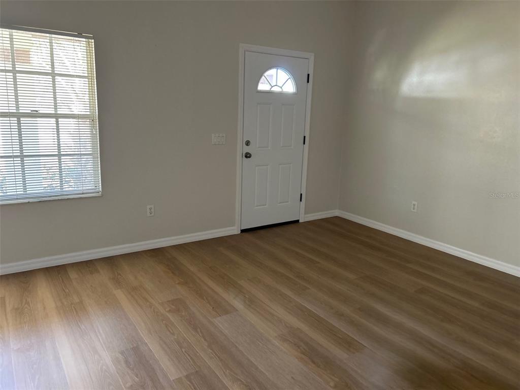 301 Oak Track Loop Ocala, FL 34472 - Photo 4 of 14 an empty room with wooden floor and windows