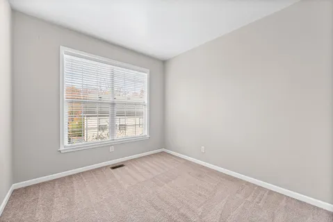 a view of empty room with wooden floor and ceiling fan