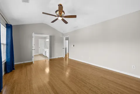 a view of empty room with wooden floor