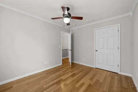 a view of a livingroom with furniture a ceiling fan and wooden floor