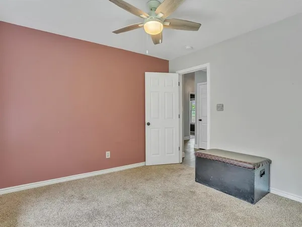 an empty room with closet and fan