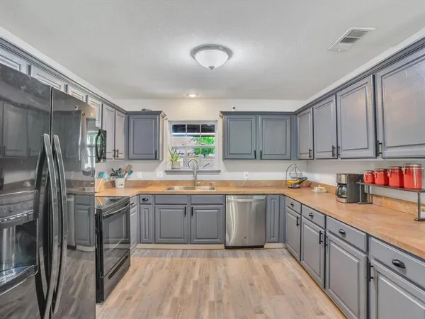 a kitchen with stainless steel appliances granite countertop a sink and cabinets