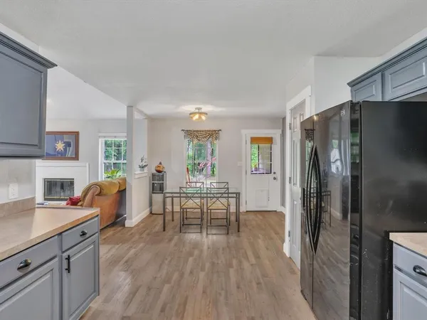 a living room with furniture wooden floor and a refrigerator